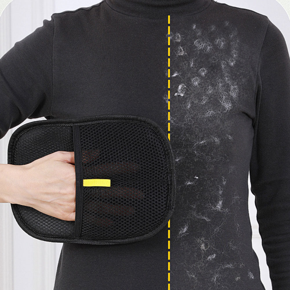 The black pet grooming glove being wiped across a dark knitted jumper