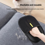 The black pet grooming glove being used on a hair-covered grey sofa