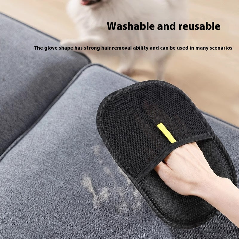The black pet grooming glove being used on a hair-covered grey sofa